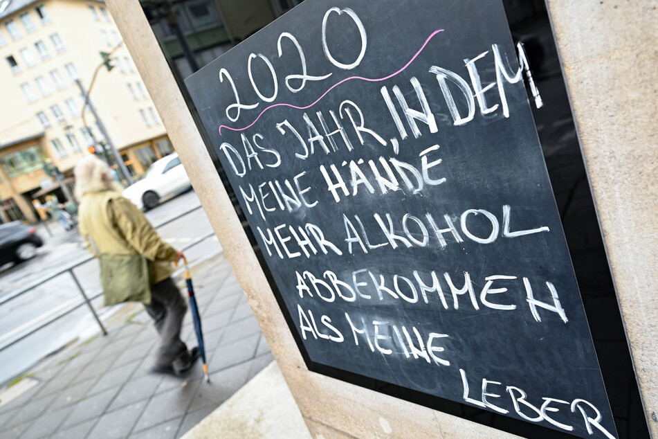 Neben dem Eingang eines Lokals in der Frankfurter Innenstadt prangt eine Tafel mit der Aufschrift "2020 - Das Jahr, in dem meine Hände mehr Alkohol abbekommen als meine Leber."