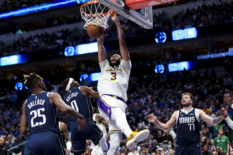 Los Angeles Lakers forward Anthony Davis dunks over Dallas Mavericks guard Justin Holiday during the fourth quarter at American Airlines Center.
