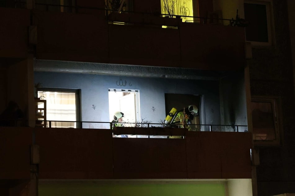 Kameraden der Dresdner Feuerwehr überprüften am Montagabend einen Balkon in Prohlis, der zuvor durch eine gezündete Rakete getroffen worden war.