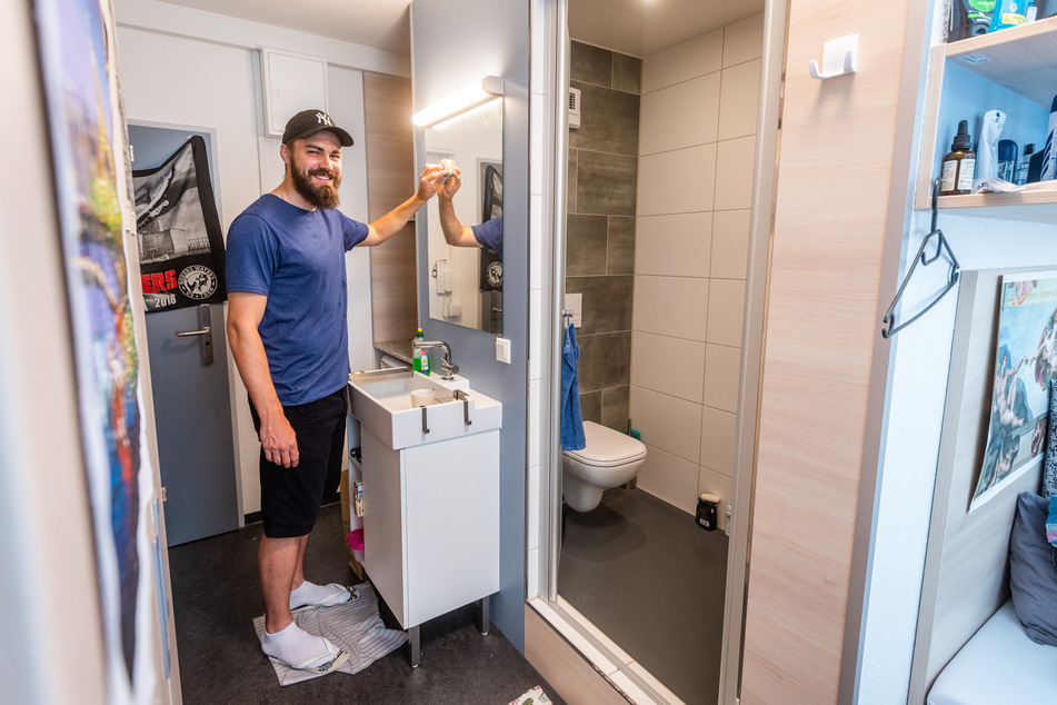 Dionatan Schmidt (27) putzt den Spiegel in seinem Zimmer mit Mikrobad.