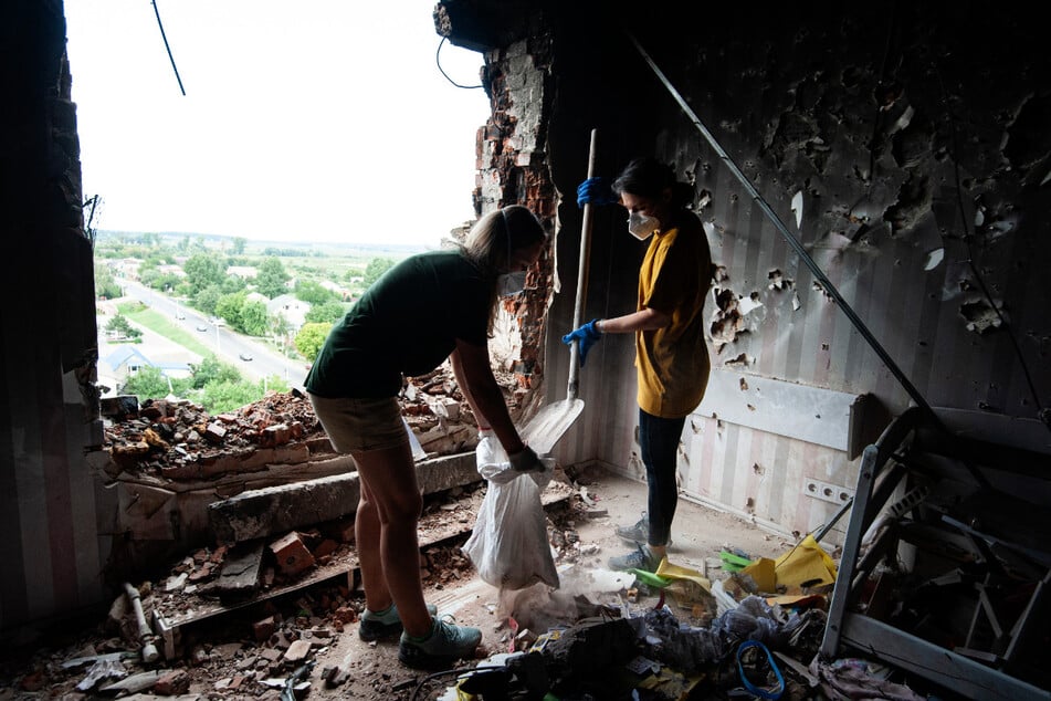 Freiwillige beseitigen Trümmer in einem Wohnhaus in Hostomel, nordwestlich von Kiew.