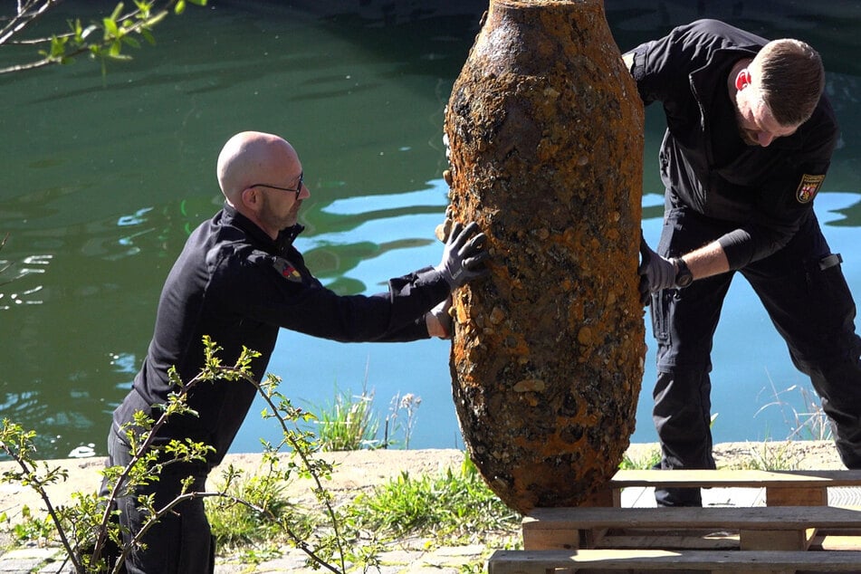 Marco Ofenstein (l.) und Sascha Hummrich vom Kampfmittelräumdienst verladen die Bombe nach der Entschärfung.