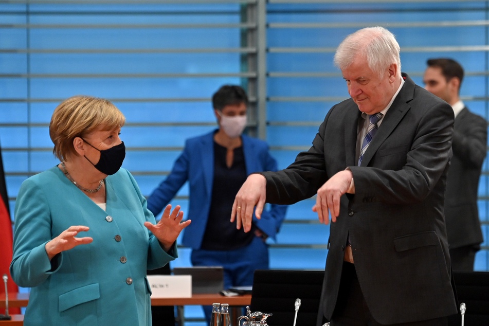 Bundeskanzlerin Angela Merkel spricht mit Horst Seehofer (CSU, r), Bundesinnenminister, bei dessen Ankunft zu einer Sitzung des Kabinettsausschusses zur Bekämpfung von Rechtsextremismus und Rassismus.
