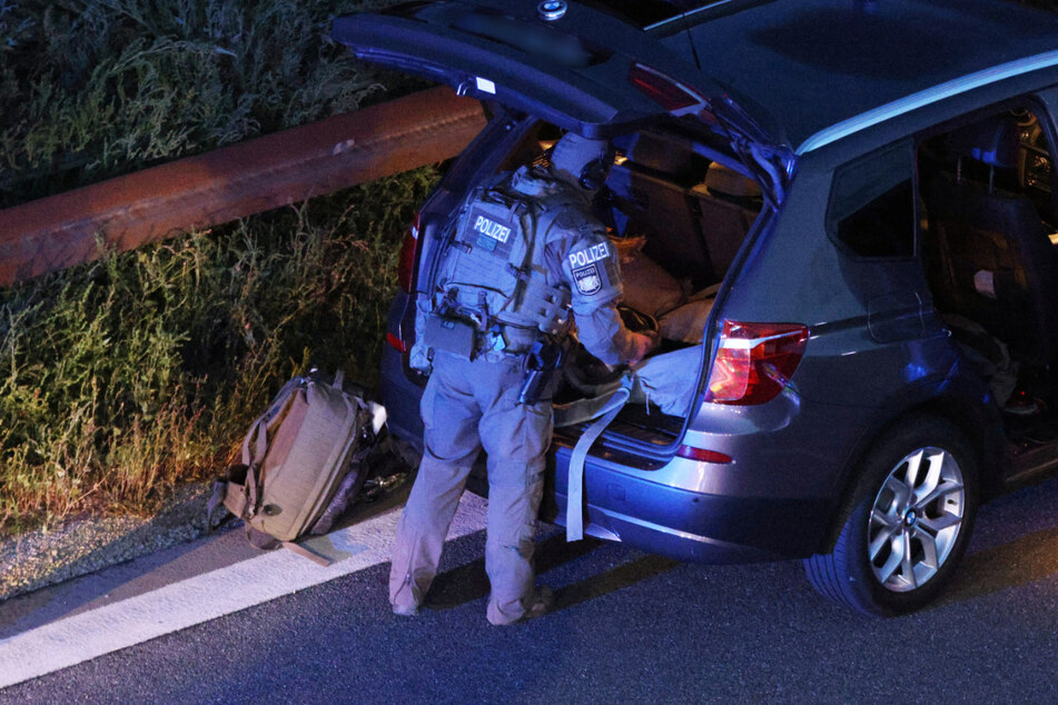 Ein Polizist mit Spezialausrüstung steht an einem Fahrzeug auf der Autobahn 9. Die Polizei war aufgrund einer möglichen Bedrohungslage mit einem Großaufgebot vor Ort.
