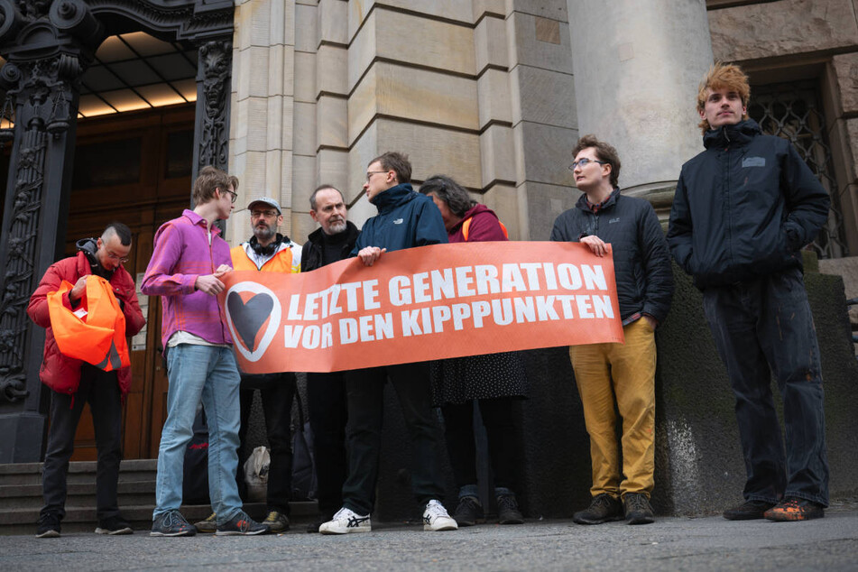 Vor dem Gerichtsgebäude haben sich einige Aktivisten der Letzten Generation versammelt, um für ihre Mitstreiter zu demonstrieren.