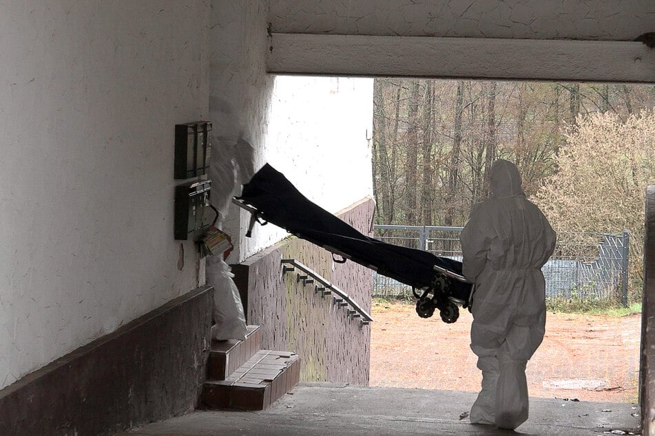 Beamte der Spurensicherung bringen einen Trage in ein Wohnhaus.