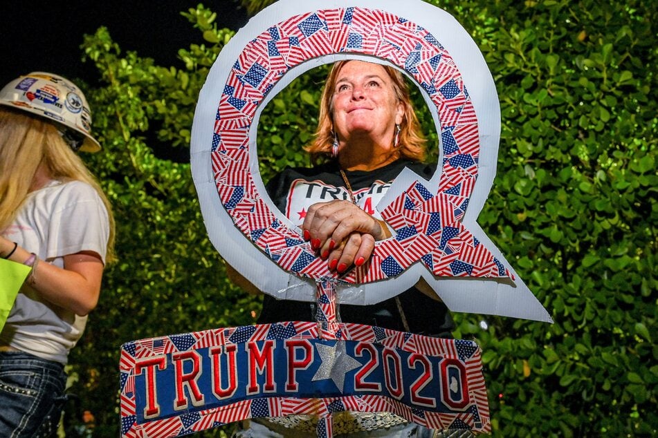 A supporter of former US President Donald Trump holds a sign associated with the Qanon conspiracy theory outside his Mar-A-Lago residence in West Palm Beach, Florida, on November 15, 2022.