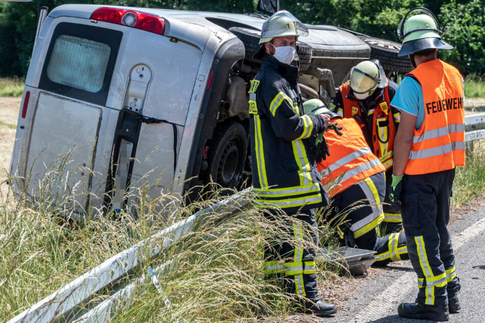 Das Foto zeigt Einsatzkräfte der Feuerwehr bei dem Wrack des Transporters.