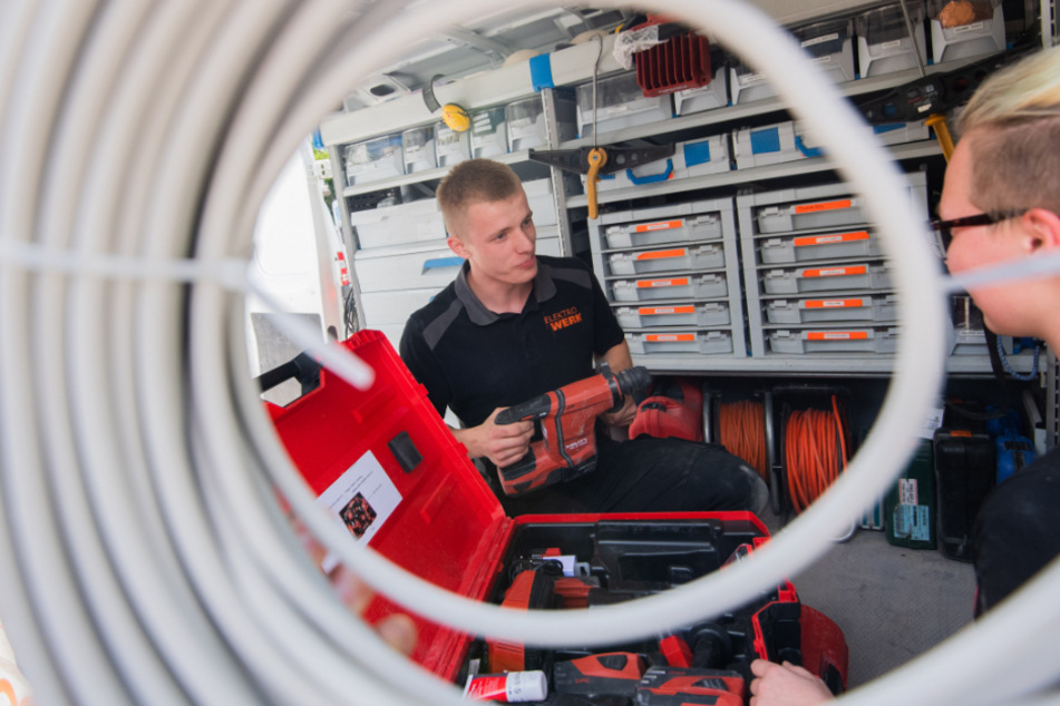 Ein Auszubildender eines Elektroinstallationsbetrieb, spricht mit einer Kollegin (Symbolfoto).