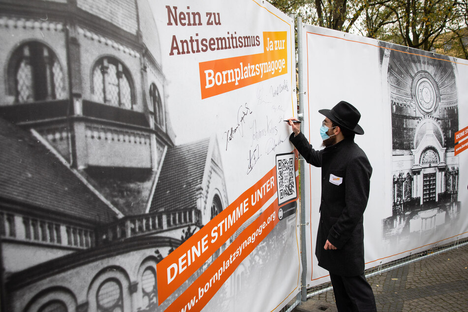 Shmuel Havlin, stellvertretender Landesrabbiner, unterschreibt auf einem Plakat zum Wiederaufbau der Bornplatzsynagoge.