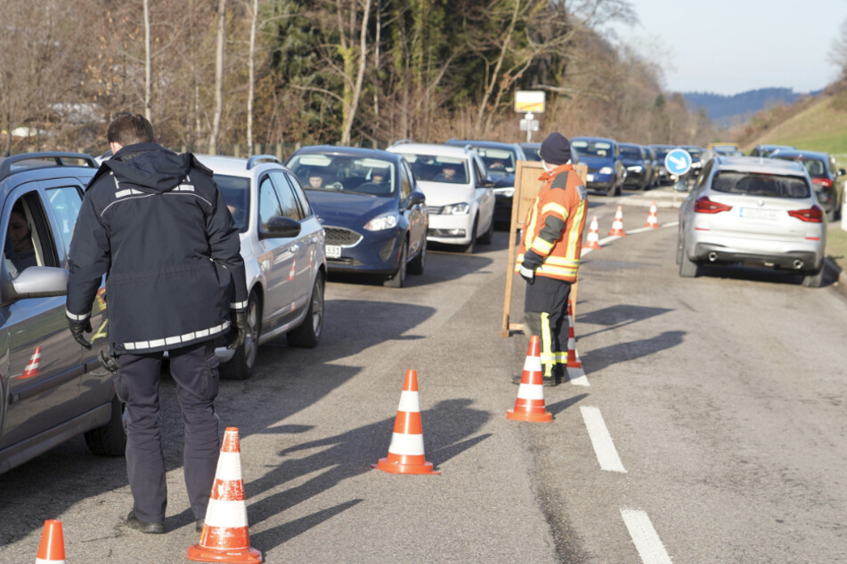 Mitarbeiter der Polizei und der Feuerwehr informieren an der gesperrten Zufahrtsstraße zur Schwarzwaldhochstraße. Auch am Sonntag haben viele Menschen das Wetter genutzt, um an winterliche Ausflugsziele im Südwesten zu fahren.