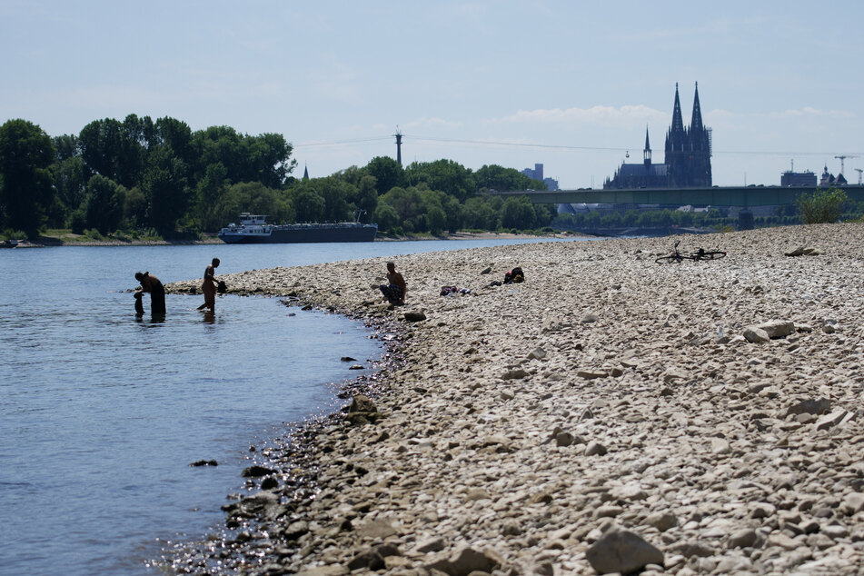Menschen genießen das sonnige Wetter am Rhein. Bis zum Wochenende soll es in NRW trocken bleiben, am Samstag rechnet der Deutsche Wetterdienst jedoch mit Starkregen.