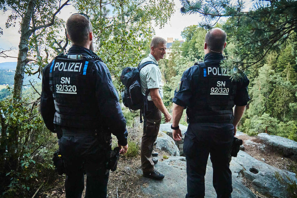 Zwei Polizeibeamte sowie ein Ranger des Nationalparks auf der Suche nach Zündlern.