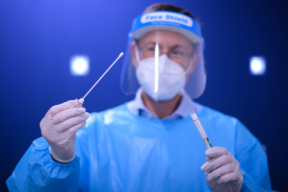 Ein Arzt der Kassenärztlichen Vereinigung Sachsen hält einen Coronavirus-Test in den Händen.