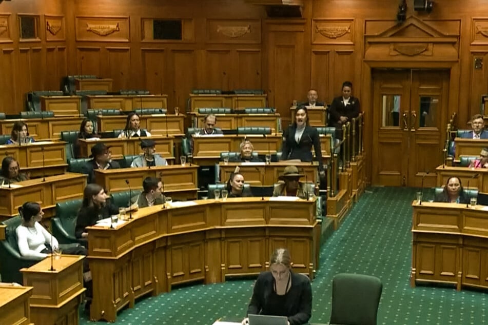Māori lawmaker Hana-Rawhiti Maipi-Clarke stands up during a first reading of the Principles of the Treaty of Waitangi Bill and performs a haka dance as she is joined by other opposition members on November 13, 2024.