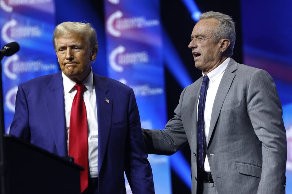 Donald Trump (l.) welcomes Robert F. Kennedy Jr. (r.) to the stage at a Turning Point Action campaign rally at the Gas South Arena on October 23, 2024 in Duluth, Georgia.