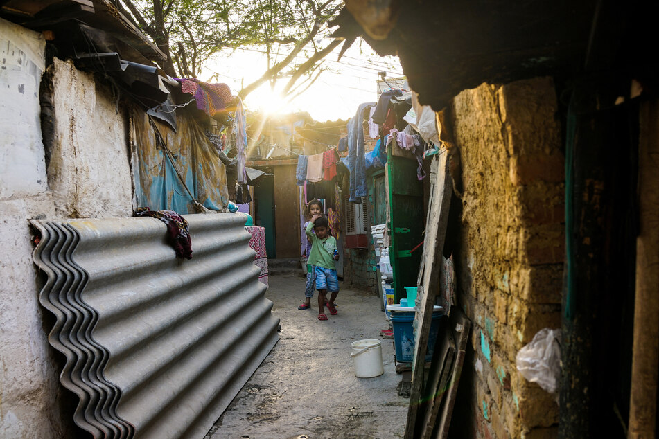 Kinder spielen vor ihrem Haus in einem der Armutsviertel von Neu-Delhi.