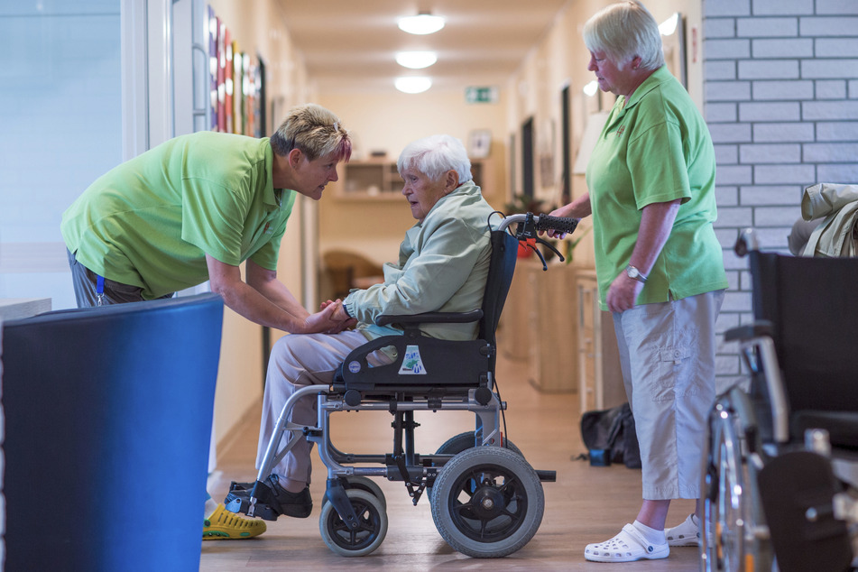 Zwei Pflegeschwestern helfen der Bewohnerin einer Wohngemeinschaft für Demenz-Kranke. Auch diese Einrichtungen überprüft die Heimaufsicht.