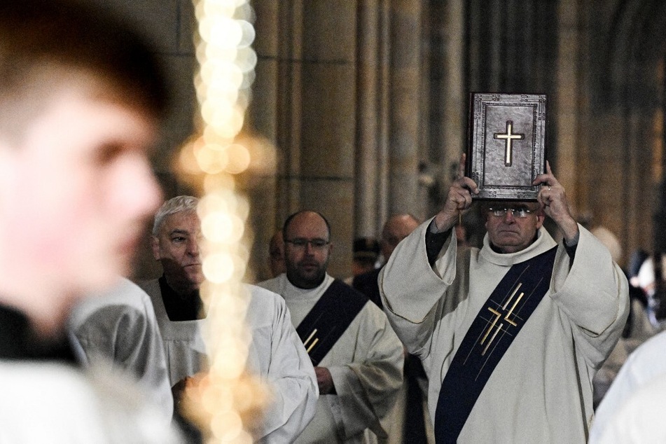 A member of the clergy carries the Bible during a mass commemorating the victims of the Charles University's shooting, at the St. Vitus Cathedral in Prague, on December 23, 2023.