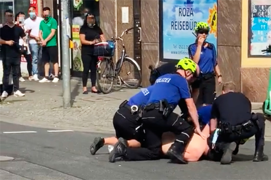 Eine Szene aus dem mittlerweile gelöschten Twitter-Video: Mehrere Polizisten knien auf einem am Boden liegenden Mann und halten ihn fest.