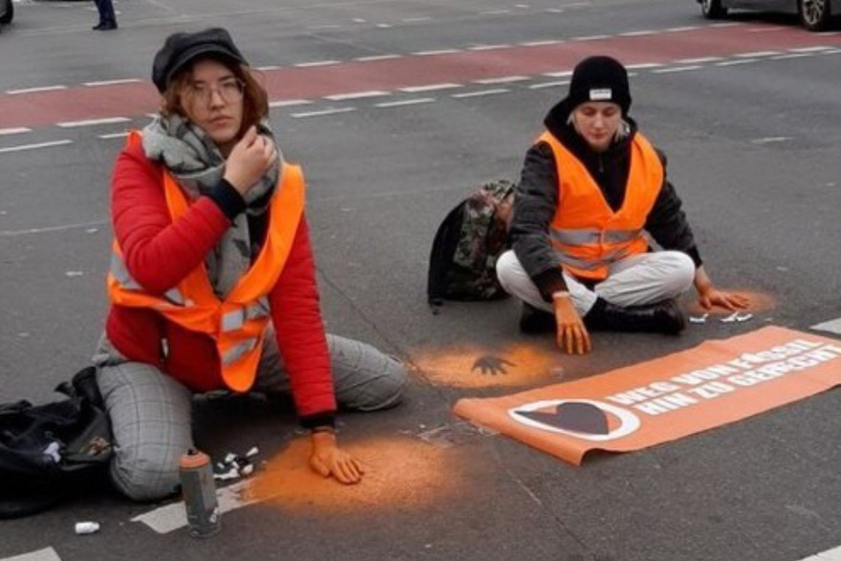Mitglieder der Klimaschutz-Gruppierung haben sich mitten auf dem Asphalt einer Berliner Kreuzung festgeklebt und hinterlassen Handabdrücke.