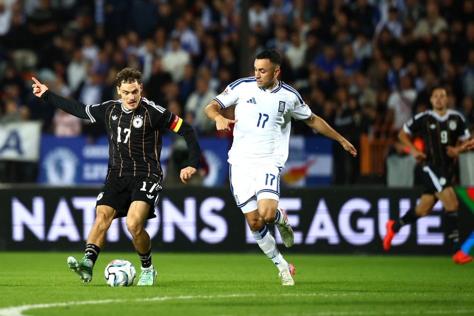 Florian Wirtz (l.) bleibt im Zweikampf mit Manolis Saliakas am Ball.