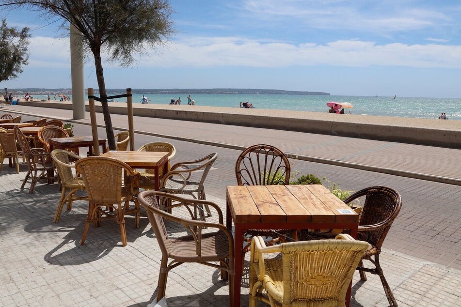 Eine leere Terrasse eines Restaurants neben dem Strand Can Pastilla in Palma de Mallorca.