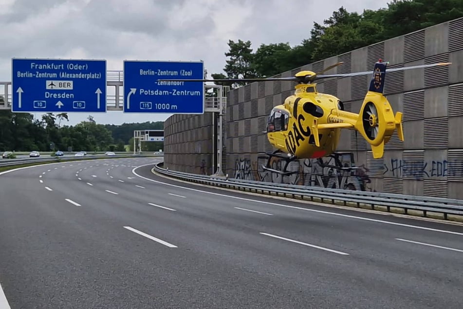 Ein Rettungshubschrauber landet auf der Autobahn, um eine schwer verletzte Person aufzunehmen.