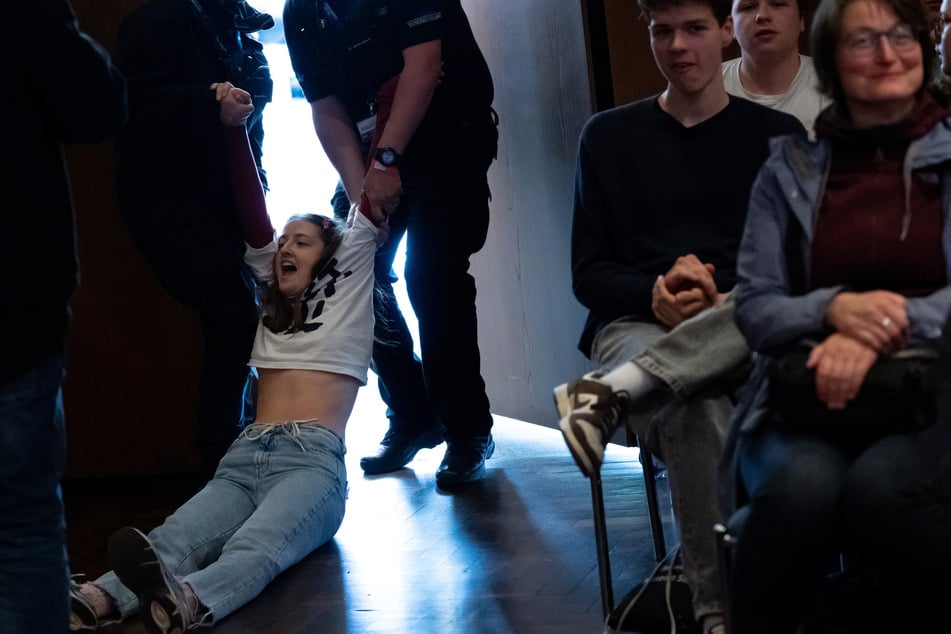Eine Frau wurde von der Security aus dem Saal geschleift.