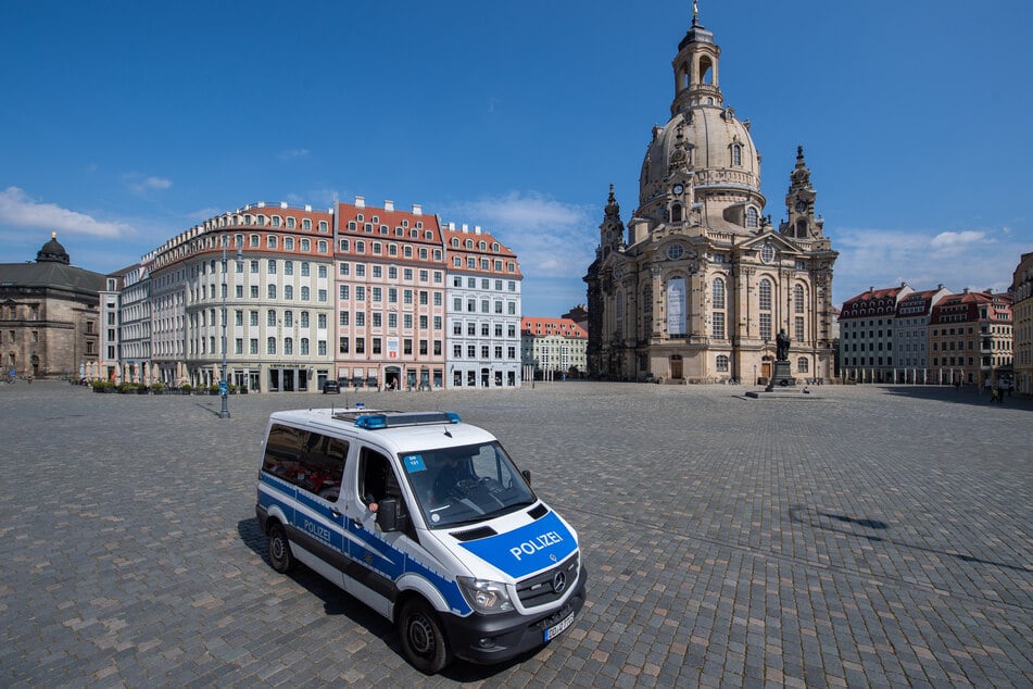 A police car crosses the nearly deserted Neumarkt in front of the Frauenkirche.