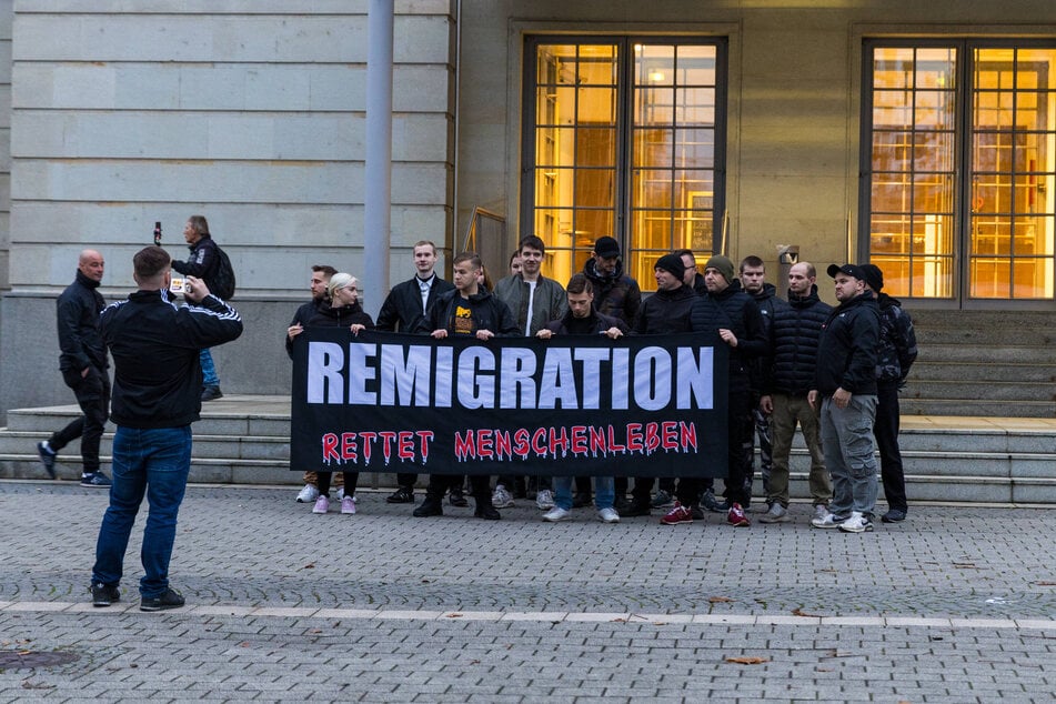 Teilnehmer der Demo halten ein Banner auf dem "Remigration rettet Menschenleben" steht.