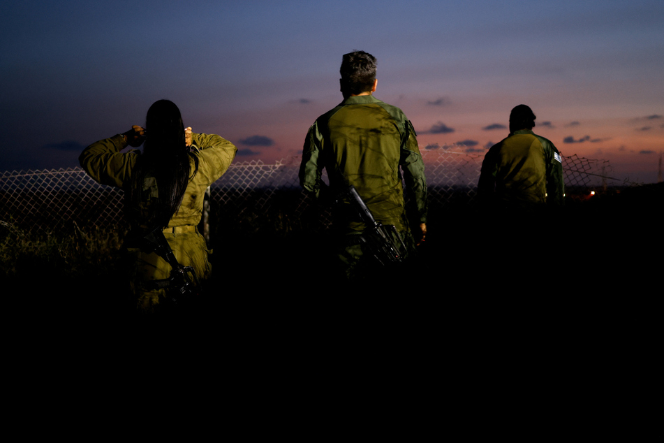 Israeli soldiers look towards northern Gaza near the border in Sderot.