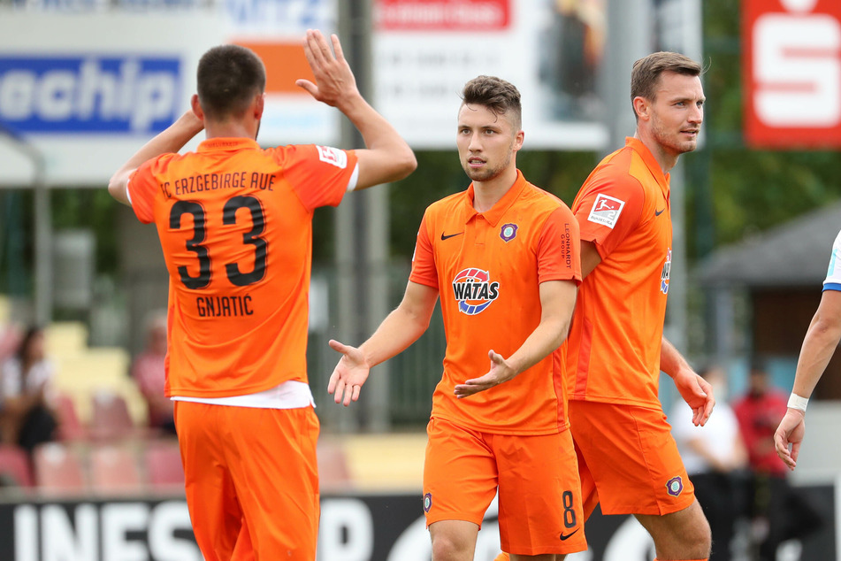 Ognjen Gnjatic (l.) freut sich mit Torschütze Tom Baumgart (M.) über das 1:0 für Aue.