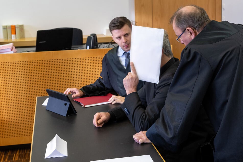 Die Anwälte Hannes Maletzke (l.) und Jörg Meringer sprechen mit ihrem Mandanten, der zusammen mit seinem Sohn angeklagt ist.