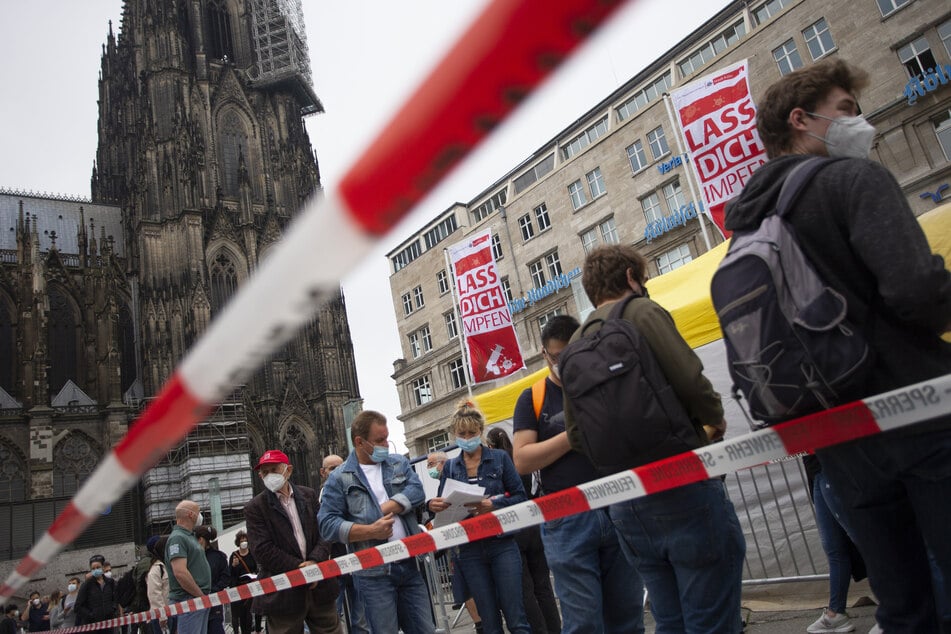 Menschen stehen Schlange bei einer Impfaktion der Stadt Köln vor dem Hauptbahnhof und dem Kölner Dom.