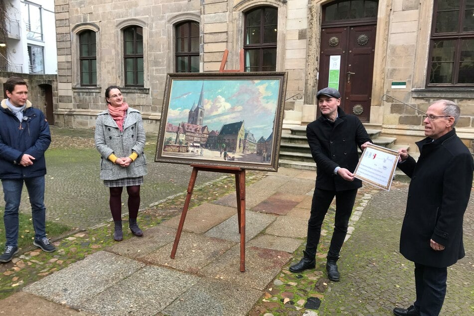 Christian Vechtel (r.) übergibt das Gemm-Gemälde an Daniel Szarata (l.), Dr. Antje Gornig und Dr. Volker Bürger, der an das Auktionshaus Münster einen Scheck in Höhe von 1000 Euro für den Erwerb des Gemäldes überreichte.
