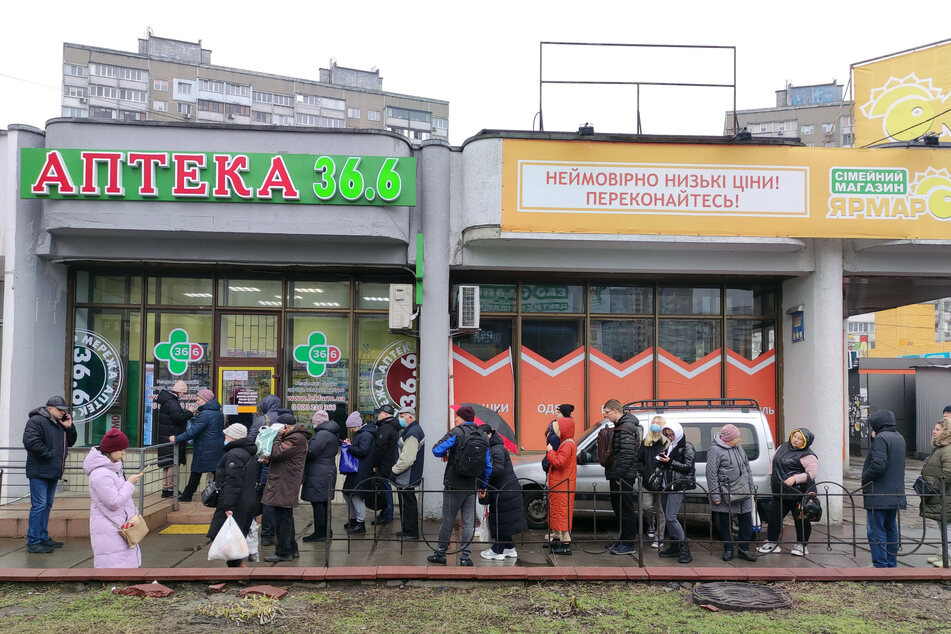 Residents stand in line at a local drug store to get supplies in Kyiv on Thursday.