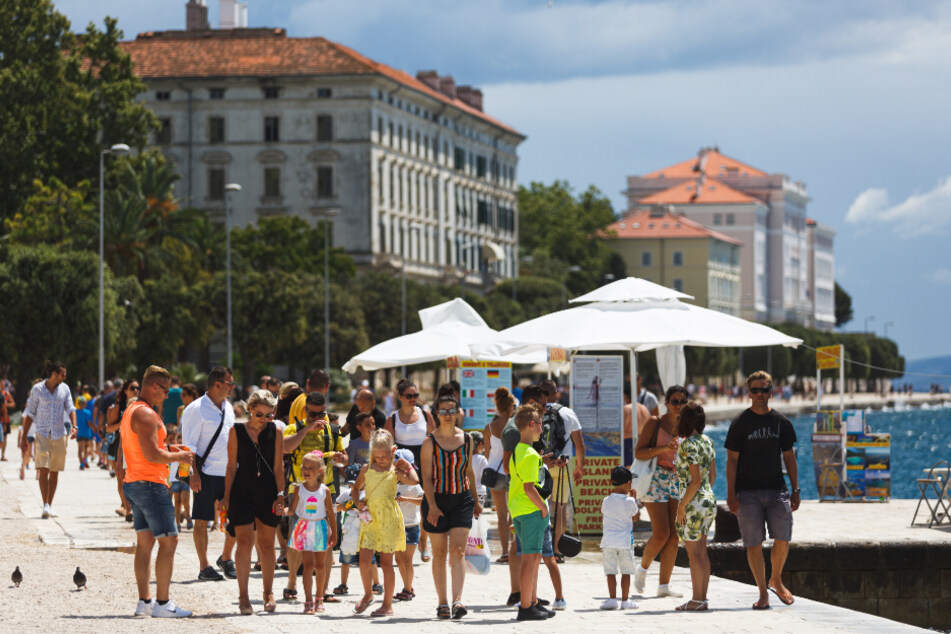 Kroatien, Zadar: Touristen spazieren an der Uferpromenade entlang.