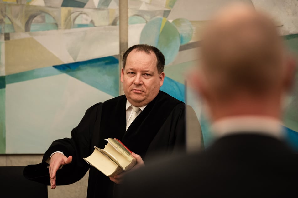 The presiding judge Mark Kurzawski (left) looks when entering the meeting room in the direction of the policeman accused of fraud and drug possession.