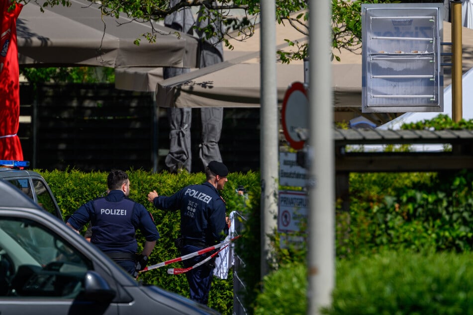 Polizisten sperren einen Bereich am Tatort ab.