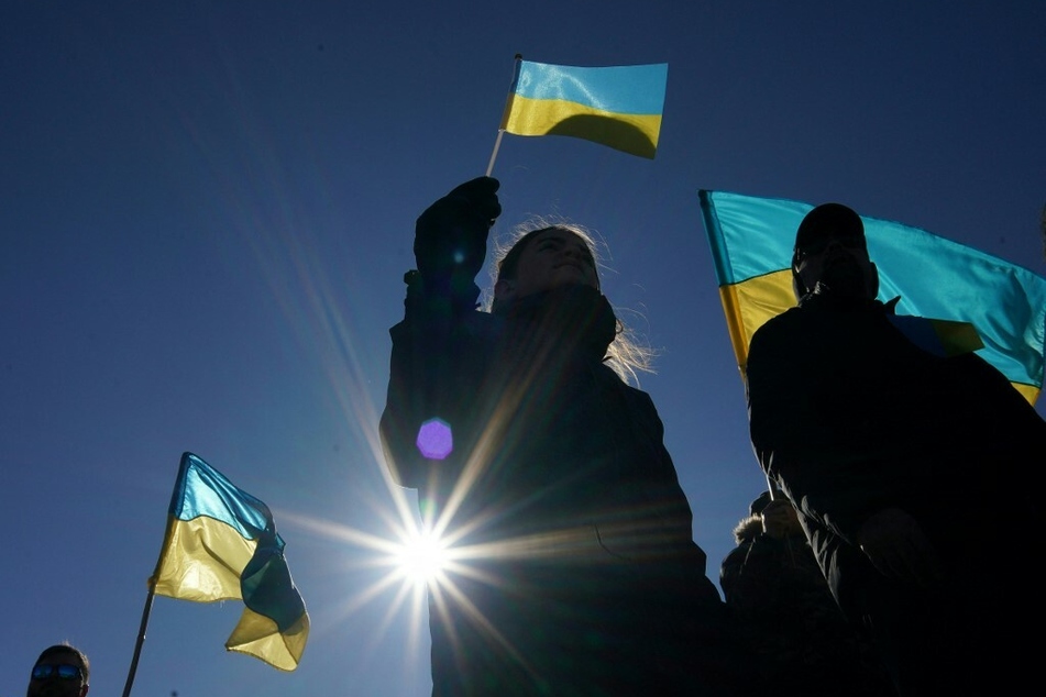 People wave Ukrainian flags during a Day of Solidarity with Ukraine at the Lincoln Memorial in Washington DC.