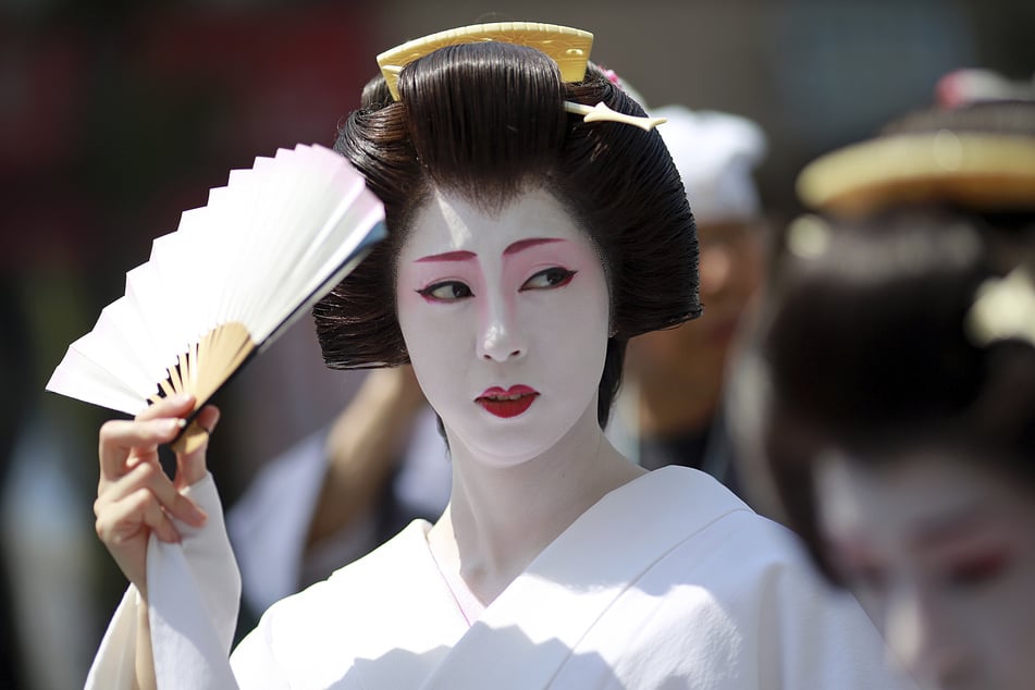 Eine Geisha ist eine japanische Unterhaltungskünstlerin. Touristen knipsen gerne Fotos von den auffällig geschminkten Frauen.