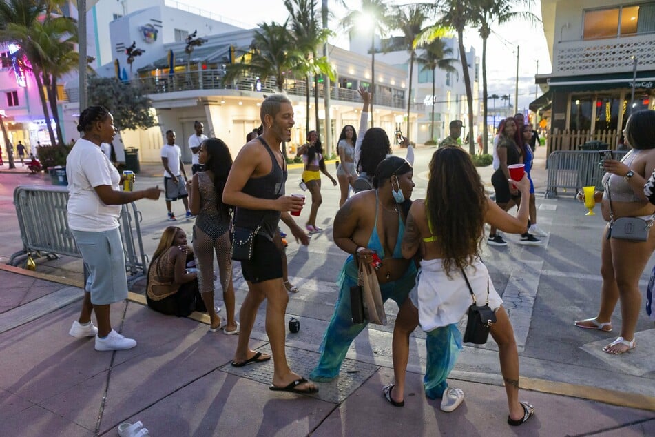 Eine Gruppe von Touristen tanzt auf dem Ocean Drive in Miami Beach. Die Ausgangssperre könnte bis Ende des "Spring Break" andauern.