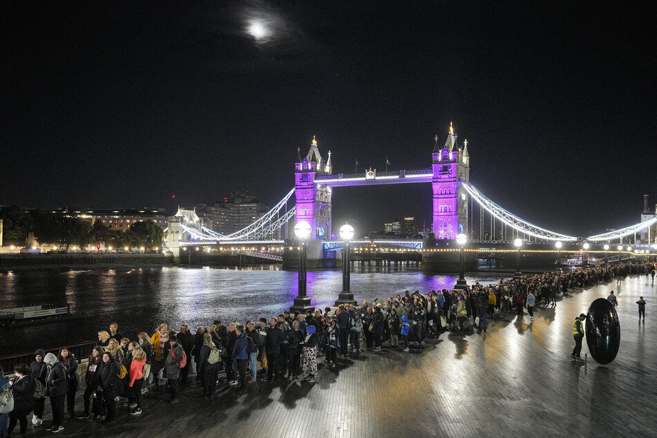 Menschen stehen vor der Tower Bridge Schlange, um der verstorbenen Königin Elizabeth II. während der Aufbahrung in der Westminster Hall in London die letzte Ehre zu erweisen.