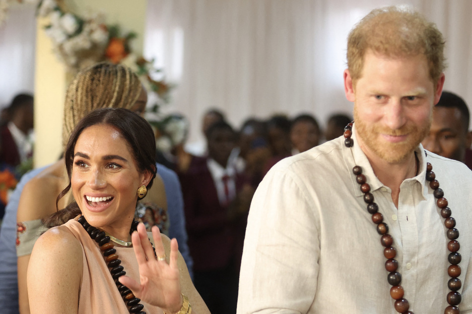 Britain's Prince Harry (r.) and his wife Meghan Markle (l.) arrive at the Lightway Academy in Abuja on Friday as they visit Nigeria as part of celebrations of Invictus Games' anniversary.