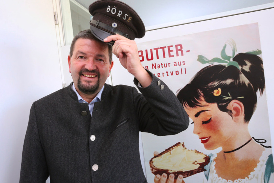 Clemens Rück, Geschäftsführer der Süddeutschen Butter- und Käse-Börse, steht in seinem Büro vor einem alten Werbeplakat.