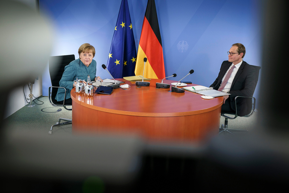 Bundeskanzlerin Angela Merkel (66, CDU, l.) und Michael Müller (56, SPD), Berlins Regierender Bürgermeister, sitzen während des digitalen Impfgipfels mit den Ministerpräsidenten der Länder an einem Tisch,
