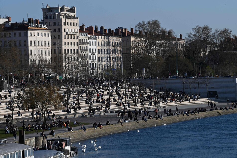 Ein Blick nach Frankreich: Menschen sitzen am 25. März am Ufer der Rhone.
