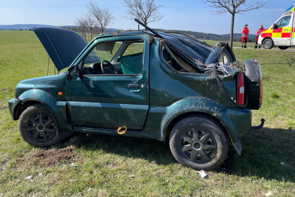 Stark beschädigt steht der verunfallte Jeep auf einem Feld.