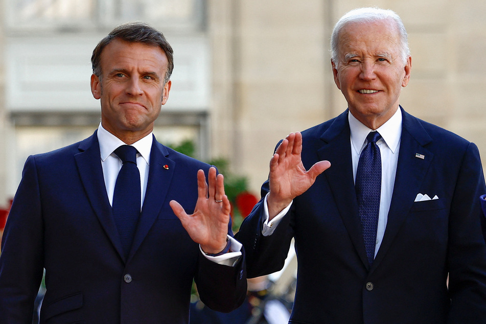 French President Emmanuel Macron (l.) and US President Joe Biden wave ahead of a state dinner at the Elysee Palace in Paris.